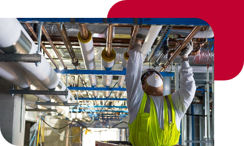 Masked worker installing insulaiton in ceiling